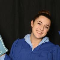 student posing with graduation cap and foam finger